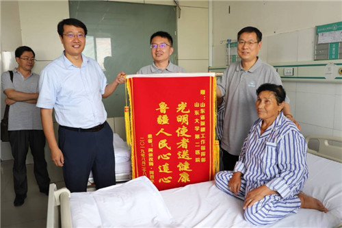 揭开纱布重建光明后的阿依孜姆·阿西木赠送锦旗表示感谢.jpg